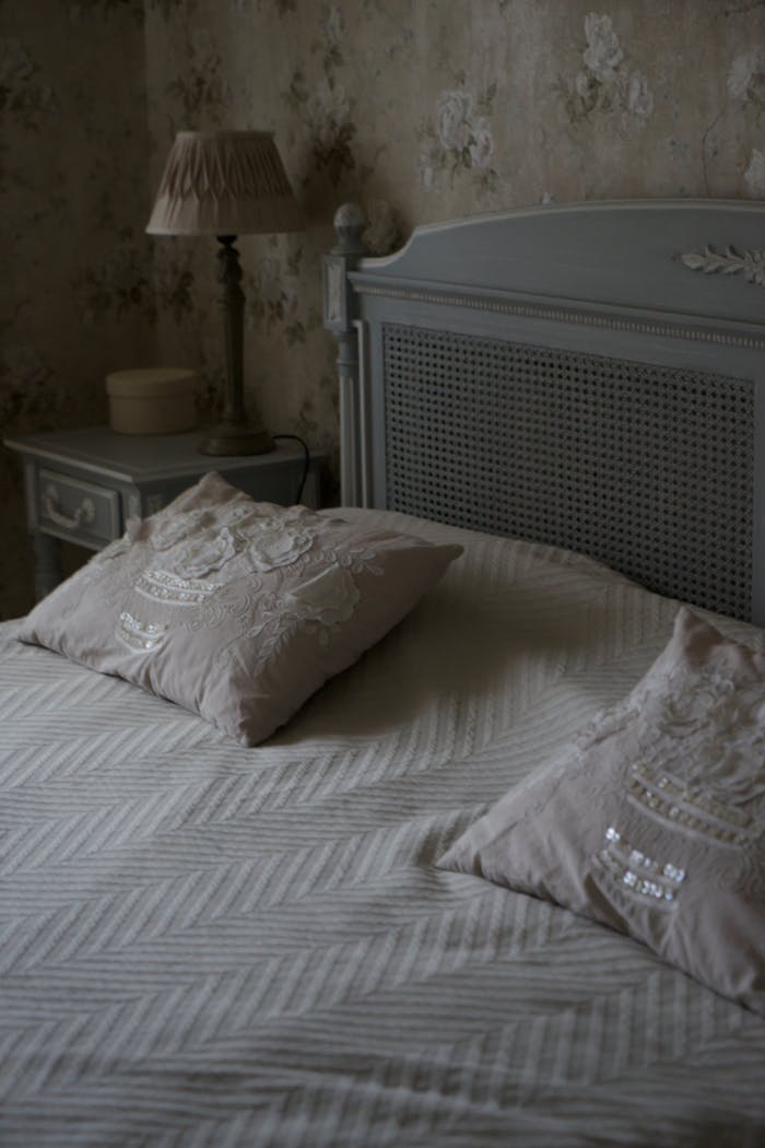 Vintage-style bedroom with elegant linens and classic decor for a cozy home ambiance.