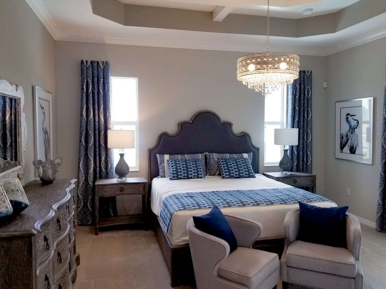 Elegant bedroom with plush furniture and ornate chandelier, ideal for home decor inspiration.
